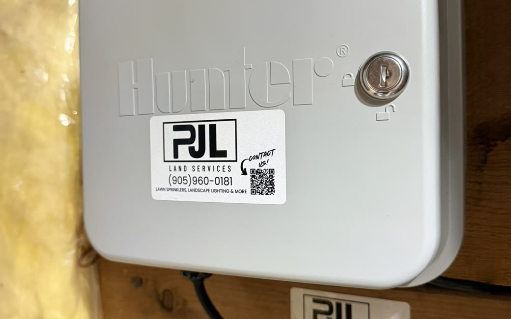 Hunter SRC sprinkler controller with a PJL Land Services service tag