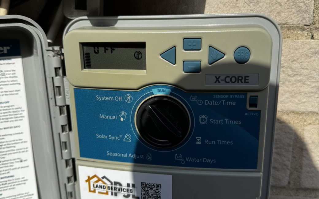 Hunter X-Core sprinkler controller faceplate showing the programming dial — tagged by PJL Land Services