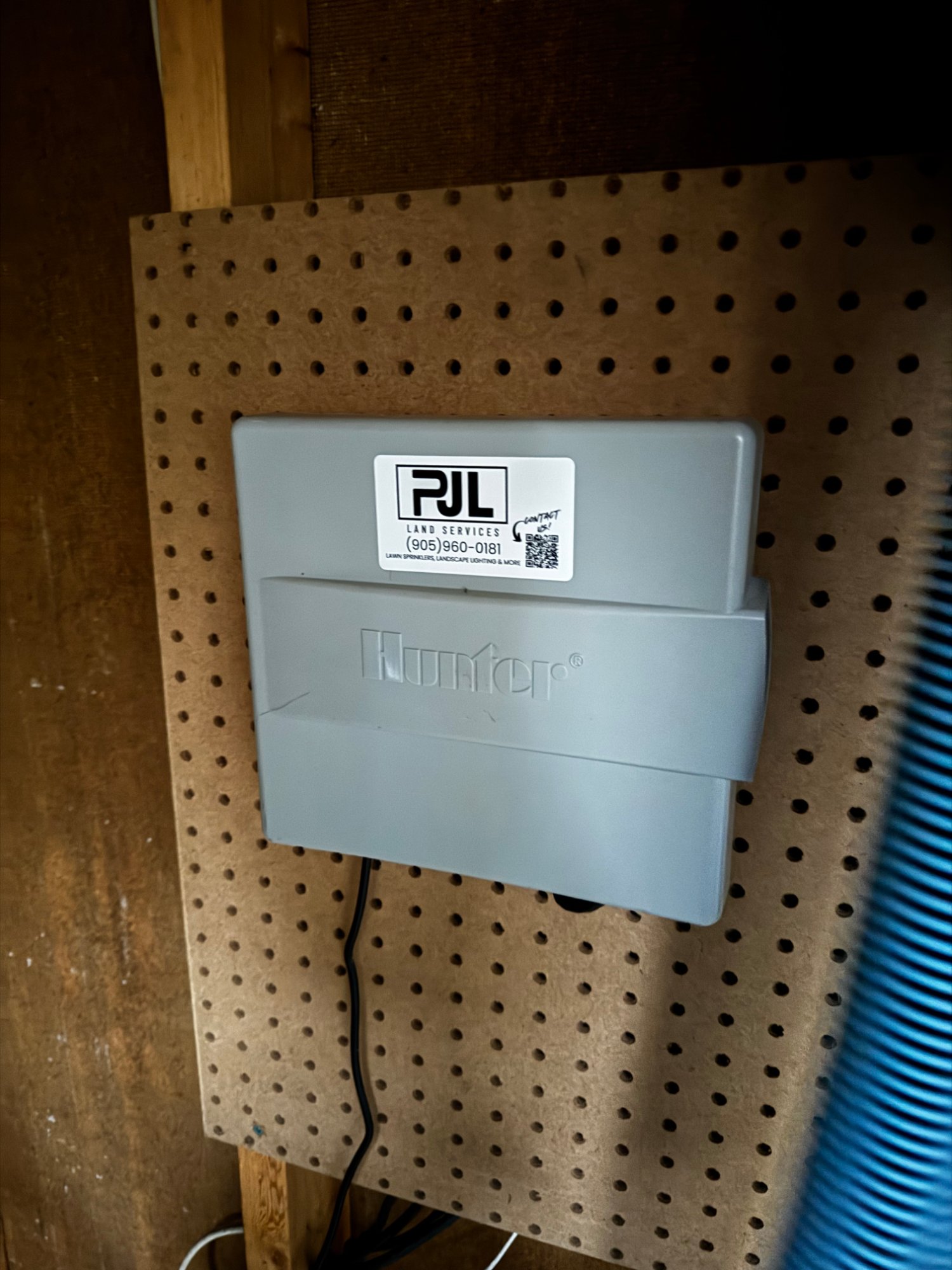 A PJL-installed Hunter Hydrawise controller mounted on a wall